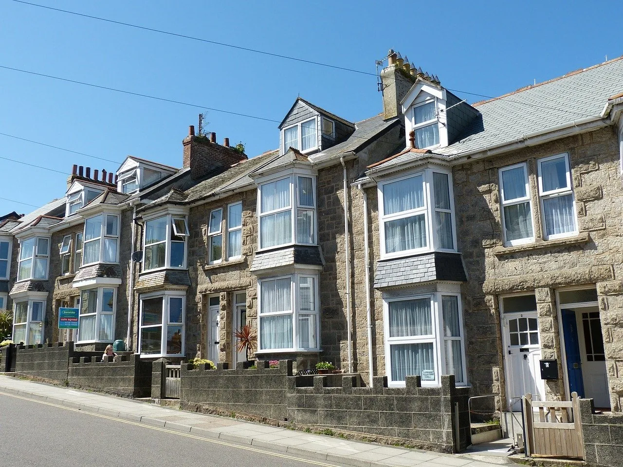 A row of stone terraced houses with bay windows